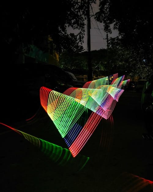 A colorfully lit movie set, with various light gels and reflectors creating a vibrant and dynamic atmosphere for filming a scene.