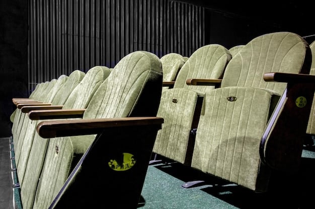 An interior shot of a luxury movie theater auditorium, featuring reclining seats, individual tables, and a waiter serving food and drinks, highlighting the enhanced comfort and dining options available.