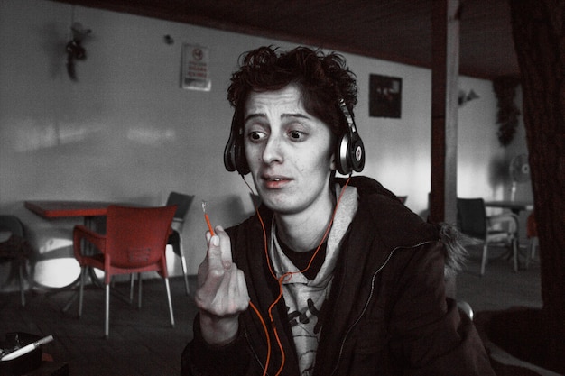 A split-screen image showing a person intently listening to a true crime podcast on headphones on one side, and a group of people watching a true crime documentary together on a TV screen on the other, highlighting the diverse ways true crime content is consumed.