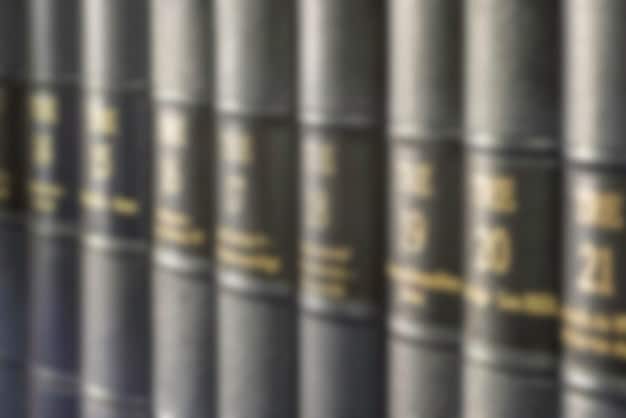 Close-up of legal documents related to copyright law, with a blurred background of film production equipment. A magnifying glass is hovering over a specific clause in the document, highlighting the complexity and scrutiny involved in copyright cases.