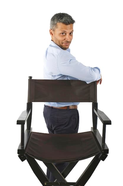 A close-up shot of a director sitting in a folding chair on a film set, intensely focused on a small monitor displaying footage. The scene is set in a somewhat gritty, urban environment, hinting at the film's low-budget nature.