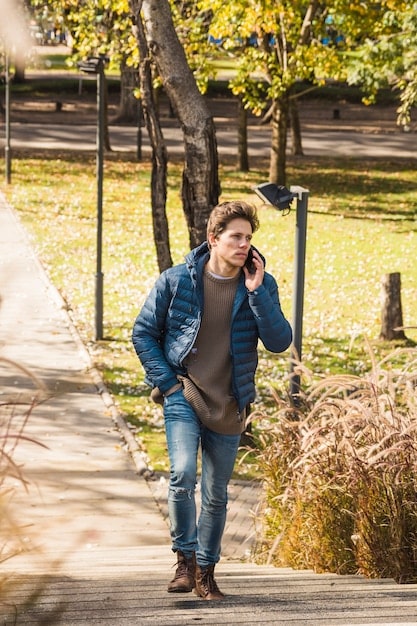 A paparazzi shot of Ben Affleck looking somewhat downcast while walking alone, wearing casual clothes and noticeably without his wedding ring. The background could be a city street or a parking lot to add context to his solo appearance.