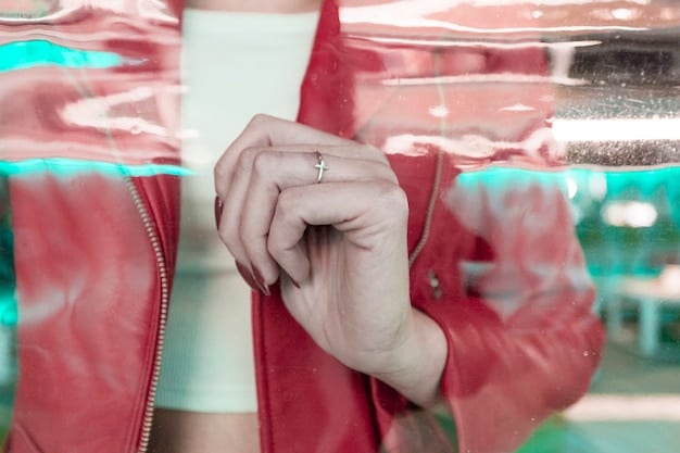 A close-up shot of Zendaya's hand, with a blurred object on her ring finger that some fans speculate could be an engagement ring. The background is dark and out of focus, highlighting the potential ring.