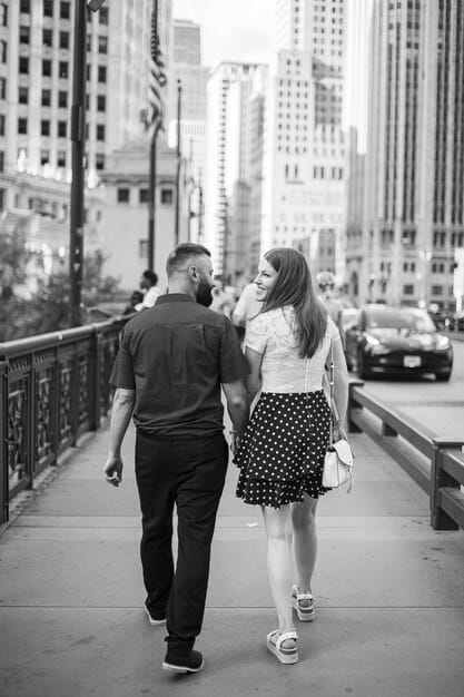 Black and white photo of Blake Lively and Ryan Reynolds walking hand-in-hand in New York City. They are dressed casually and appear relaxed, blending in with the crowd.