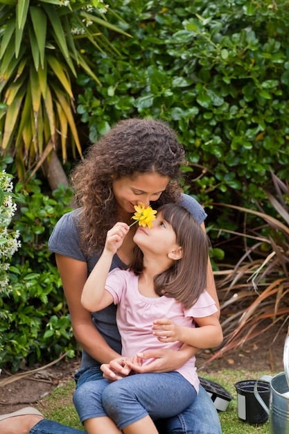 A candid photo of Rihanna holding her first child, RZA, with a loving and protective expression. They are in a park, surrounded by greenery.
