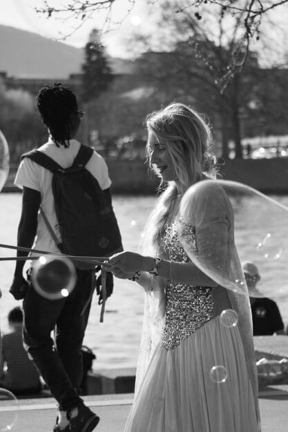 A black-and-white photo of Justin and Hailey Bieber at their wedding ceremony. They are holding hands and looking into each other's eyes, conveying a sense of love and commitment. The image should have a romantic and intimate feel.
