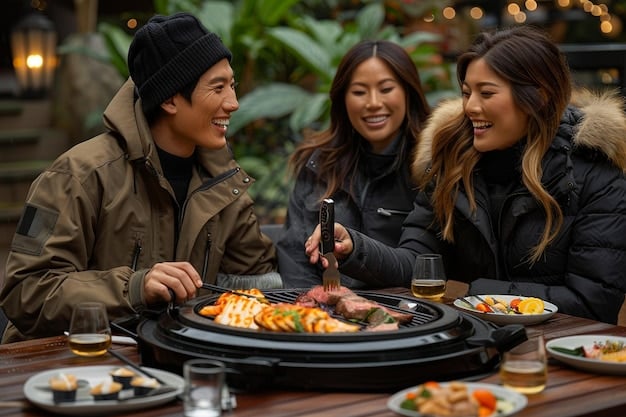 A group of K-drama fans enjoying a meal together at a Korean BBQ restaurant. They are smiling and engaged in conversation, while Korean side dishes and grilling meats are visible on the table.