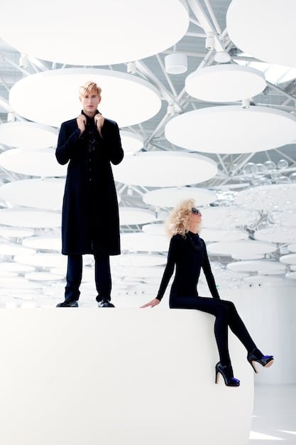 A split image featuring a designer runway show on one side and a scene from a popular K-drama on the other. The runway show features models wearing outfits with pastel colors, oversized blazers, and unique accessories. The K-drama scene shows actors in similar outfits, highlighting the parallel between high fashion and K-drama styles.