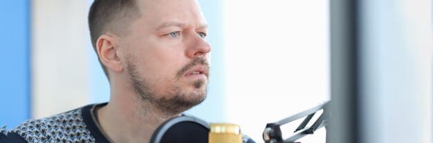 A close-up shot of a voice actor in a recording studio dubbing lines for a Korean drama, showcasing the dubbing process. The actor is wearing headphones and reading from a script, with a microphone in front of them.